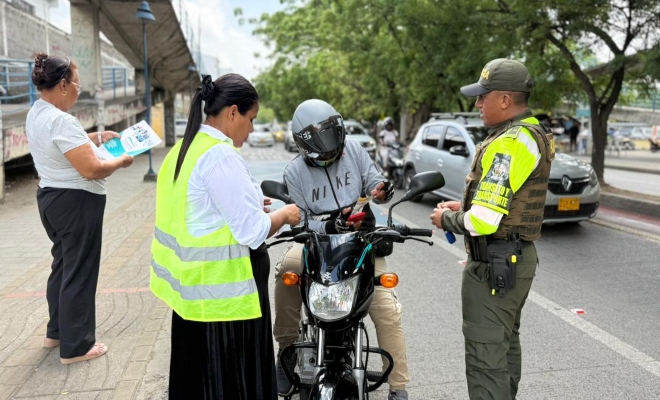 un uniformado adscrito a la seccional de transito y transporte  con dos funcionarios de la administración y un ciudadano en  campaña de prevención 