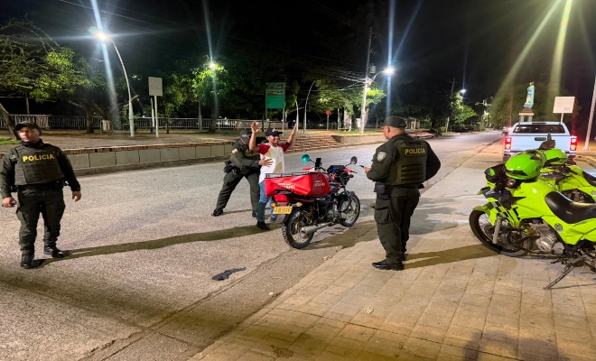 tres uniformados de la Policía nacional  realizan registro a un ciudadano en vía publica en la ciudad de Montería  