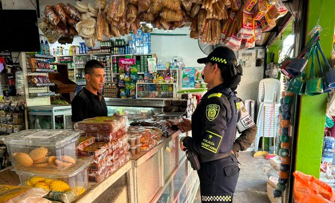 Funcionarias policiales brindando recomendaciones de seguridad a tenderos
