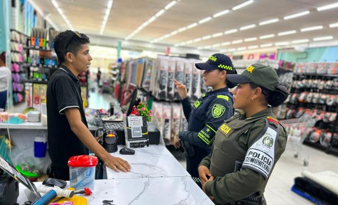 Funcionarias policiales brindando recomendaciones a tenderos en el sector comercio en Ciénaga de Oro