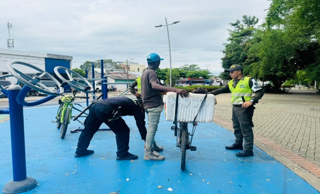 tres uniformados realizando un registro a una persona  en parque principal de la ciudad de Montería