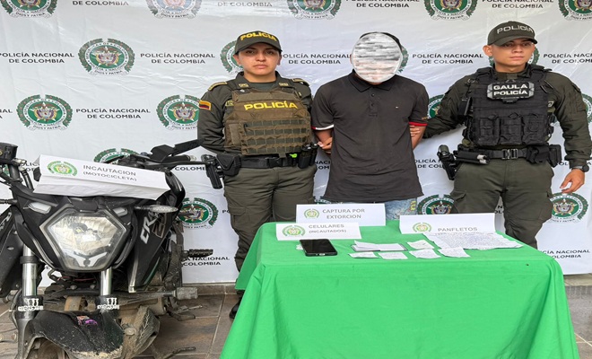 Una motocicleta y un capturado custodiado por dos policías