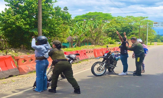 Dos policías realizan registro personal a dos motocicletas en la vía nacional 