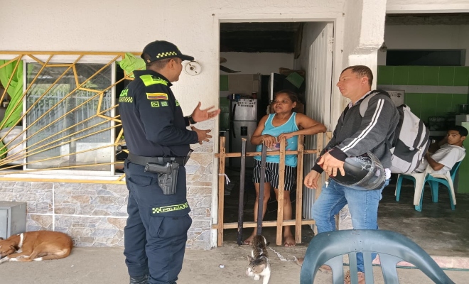 Un uniformado con  dos ciudadanos en campáña educativa sobre el hurto a residencias 