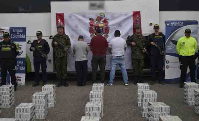 Policías ejercito custodiando cigarrillos de contrabando y personas capturadas