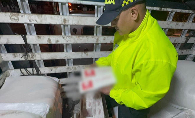 Policía revisando cigarrillos incautados