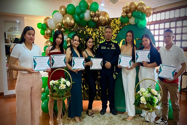 Un policía uniformado y siete auxiliares de Policía posan para una fotografía