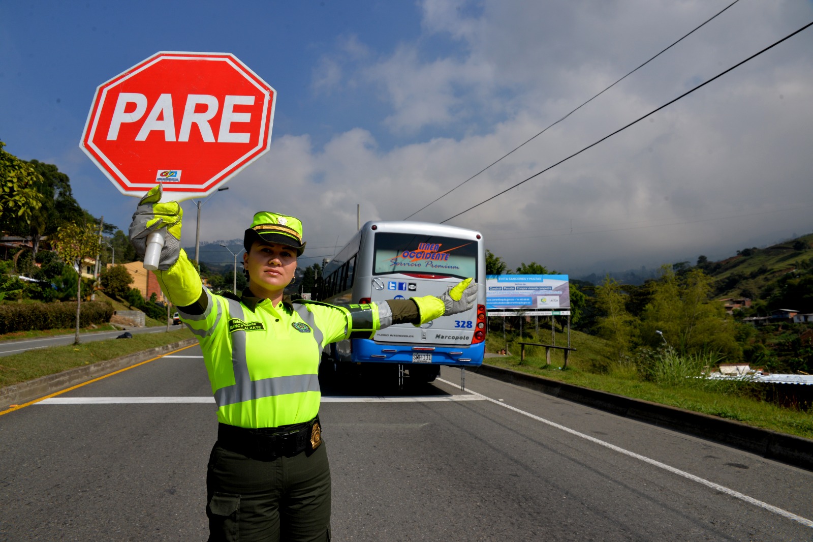 Policía en una vía con señal de trásito de pare 