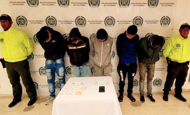 Personas capturadas-policías custodiando