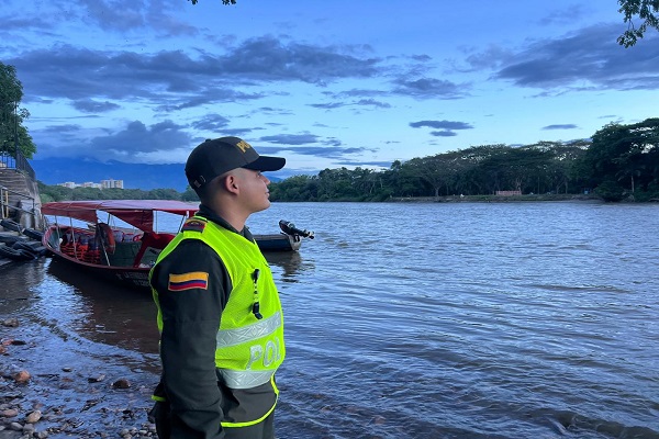 Auxiliar de Policía de Turismo observa el río Magdalena durante una jornada de prevención
