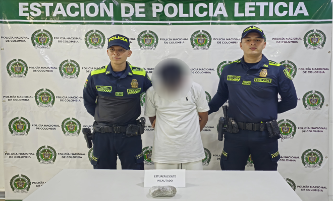 Dos polic&iacute;as, una persona capturada y encima de una mesa estupefacientes incautados