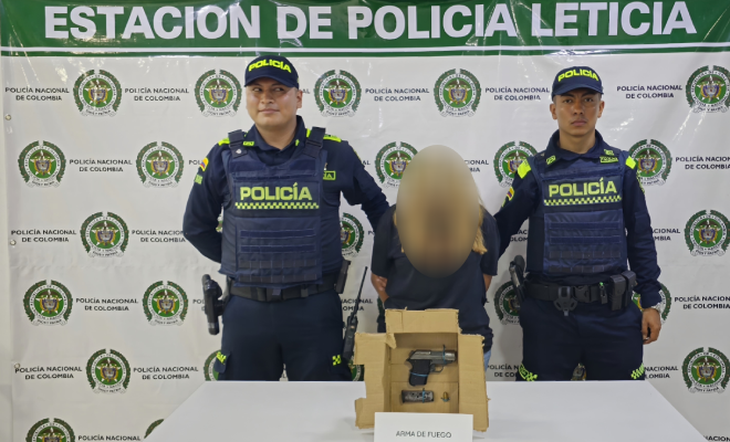 Dos_polic&iacute;as_una_ciudadana capturada,_encima de una_mesa_una_pistola incautada