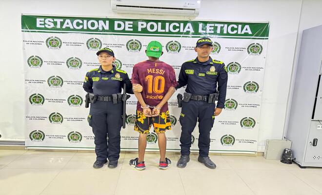 Dos polic&iacute;as  y una persona capturada de espaldas
