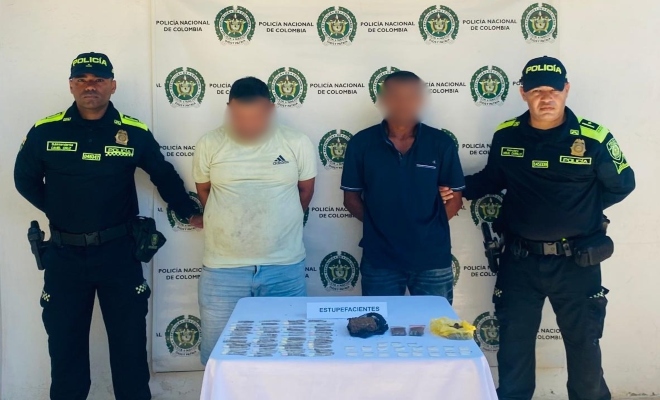dos policias custodian a dos sujetos y sus elementos incautados