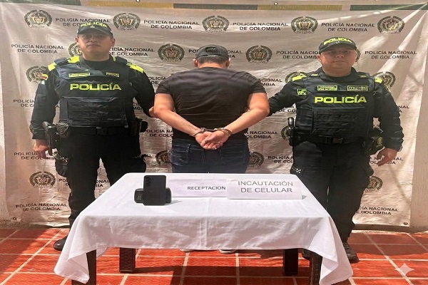 Dos Policías, un capturado por el delito de receptación , mesa con teléfono celular