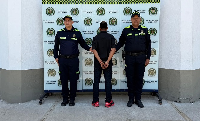 Una persona capturada por orden judicial por el delito de homicidio y fabricación, tráfico, porte o tenencia de armas de fuego, accesorios, partes o municiones, acompañado de dos uniformados de la Policía Nacional brindando seguridad.