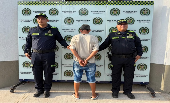 Una persona de sexo masculino de espaldas, capturado por el delito de Violencia Intrafamiliar, dos uniformados de la Polic&iacute;a Nacional brindando seguridad