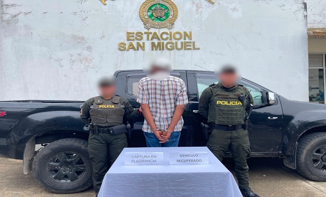 Dos policías, una Camioneta de fondo, al frente dos personas con la persona capturada 