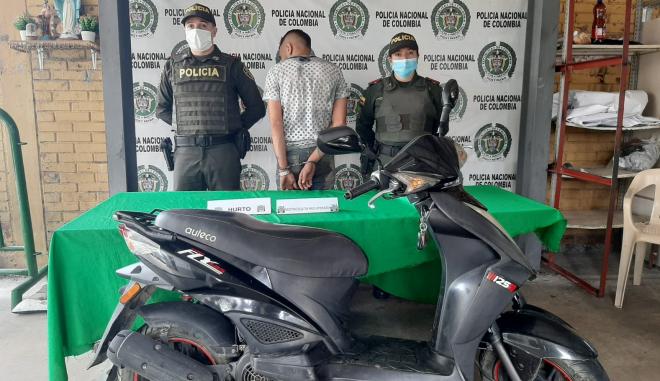 Motocicleta recuperada-policías custodiando-una persona capturada