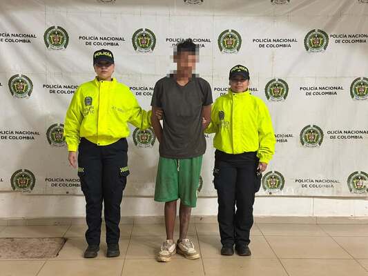Dos policías sosteniendo a un capturado
