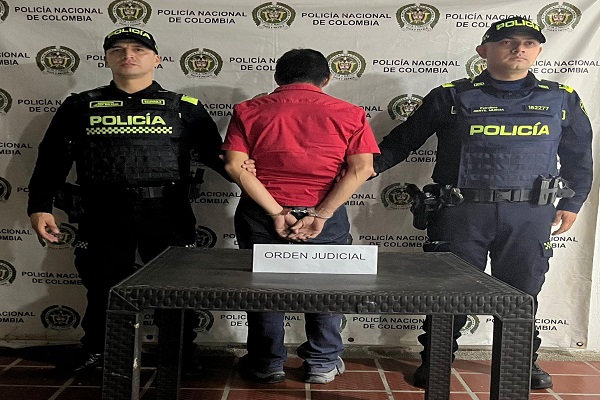 Dos uniformados custodian a un hombre capturado