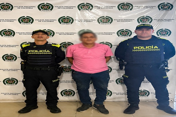 Dos policías uniformados sostienen del brazo a un hombre capturado