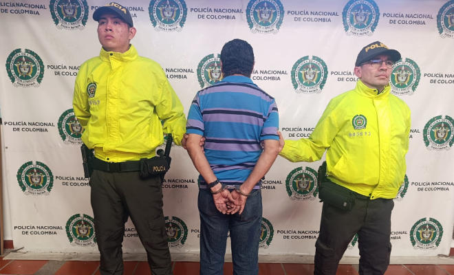 Hombre capturado en medio de dos Policías