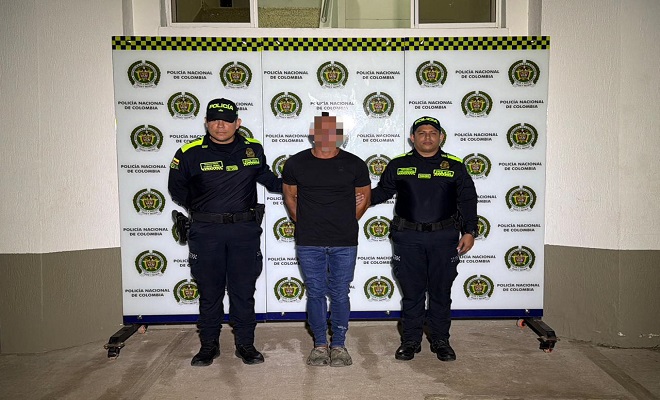 Un hombre capturado por el delito de homicidio en medio de dos funcionarios de la Policía Nacional que lo sujetan y brindan seguridad 