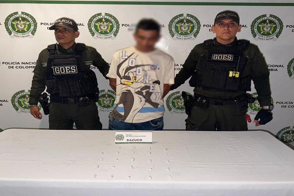 Dos Policías, un capturado, mesa con estupefacientes