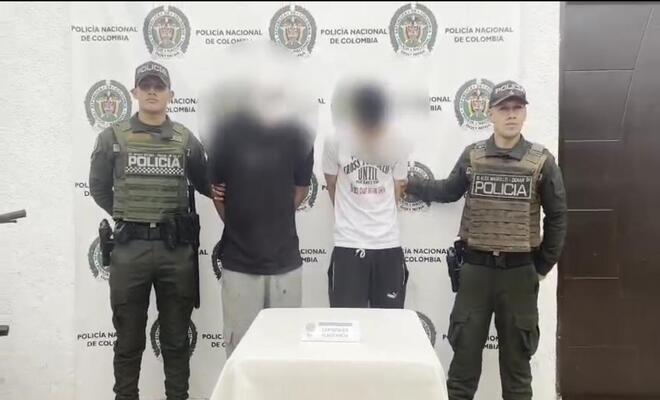 Dos personas capturadas por hurto y esposadas con dos Policías a sus lados respectivamente 