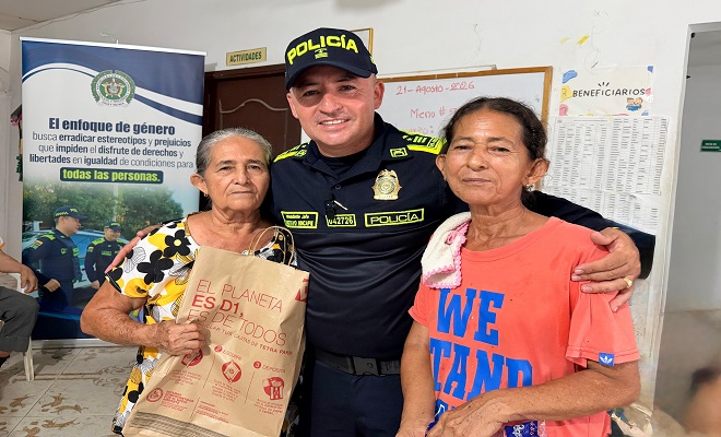 Un funcionario de la Policía Nacional acompañado de dos personas beneficiadas de la actividad 