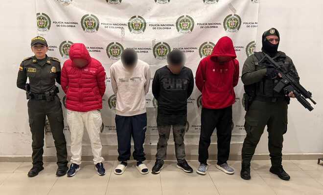 Cuatro hombres capturados con dos polic&iacute;as a su lado