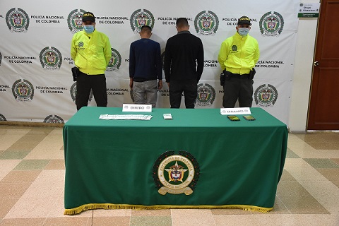 Dos personas capturadas-policías custodiando
