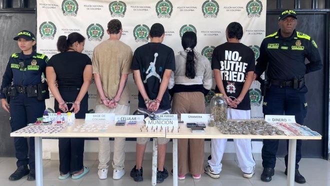 Dos polic&iacute;as al lado de cinco capturados con elementos