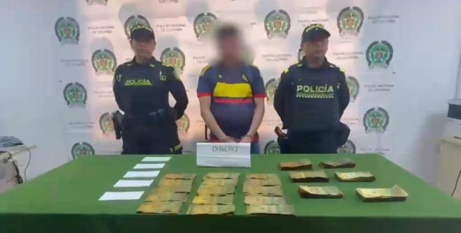 Dos polic&iacute;as al lado de un hombre capturado