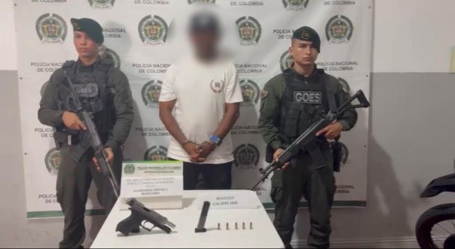 Dos polic&iacute;as al lado de un hombre capturado