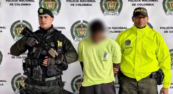dos polic&iacute;as al lado de un hombre detenido