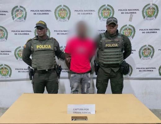 Dos policías al lado de un hombre capturado