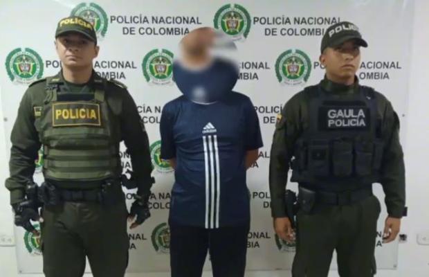 Dos polic&iacute;as al lado de un hombre capturado