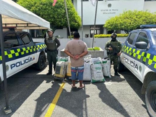 Dos polic&iacute;as al lado de un hombre capturado con carb&oacute;n 