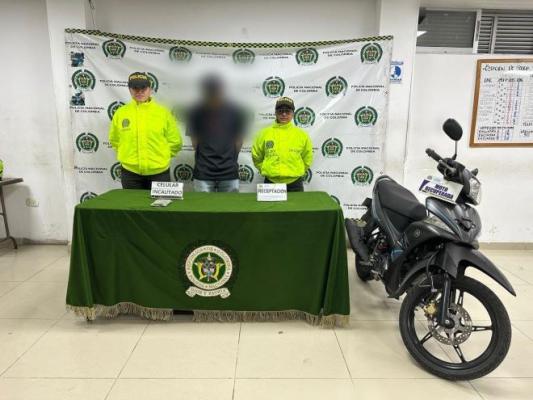 dos policías al lado de un hombre capturado material incautado