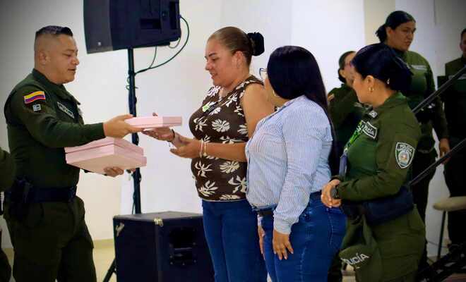 Entrega de un detalle a civiles y una uniformada en medio de la actividad.