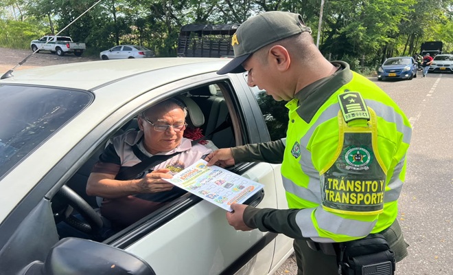 Un polic&iacute;a de Transito y Transporte junto a un ciudadano, brindando recomendaciones.