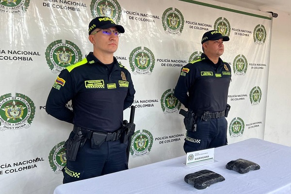 Dos Policía con el hallazgo de sustancia estupefacientes encima de una mesa
