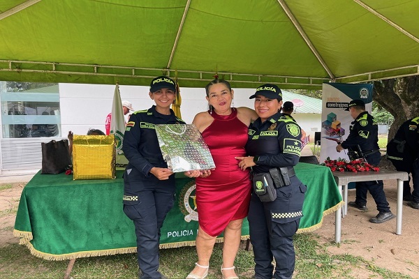 Dos uniformados acompañan e interactúan con una líder comunitaria durante la actividad
