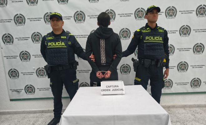 un capturado  con orden judicial y dos policías que realizan la captura
