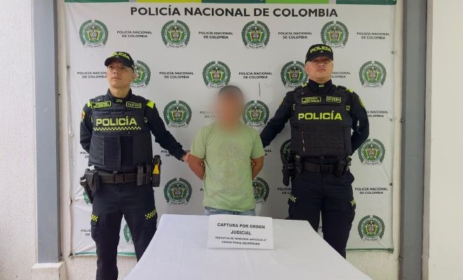 una persona capturada con orden judicial y dos policias captores