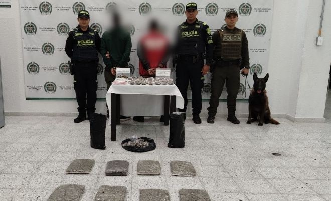 dos personas capturadas, dos polic&iacute;as que efectuaron la captura y un canino