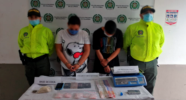 2 personas capturadas-policías custodiando-alucinógenos incautados