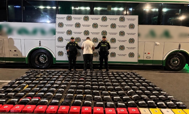 bus persona vestida de blanco, dos policías y paquetes de estupefacientes en el piso